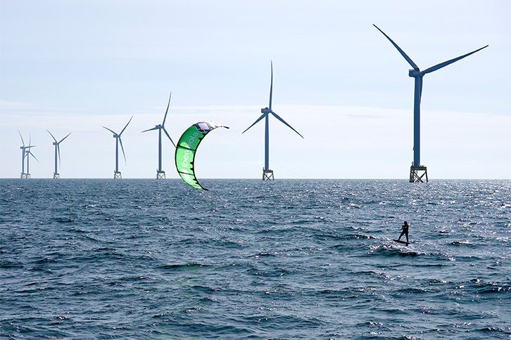 World champion kitesurfer sails amongst wind turbines